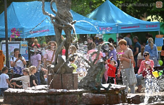 Dzieci i dorośli przy fontannie.